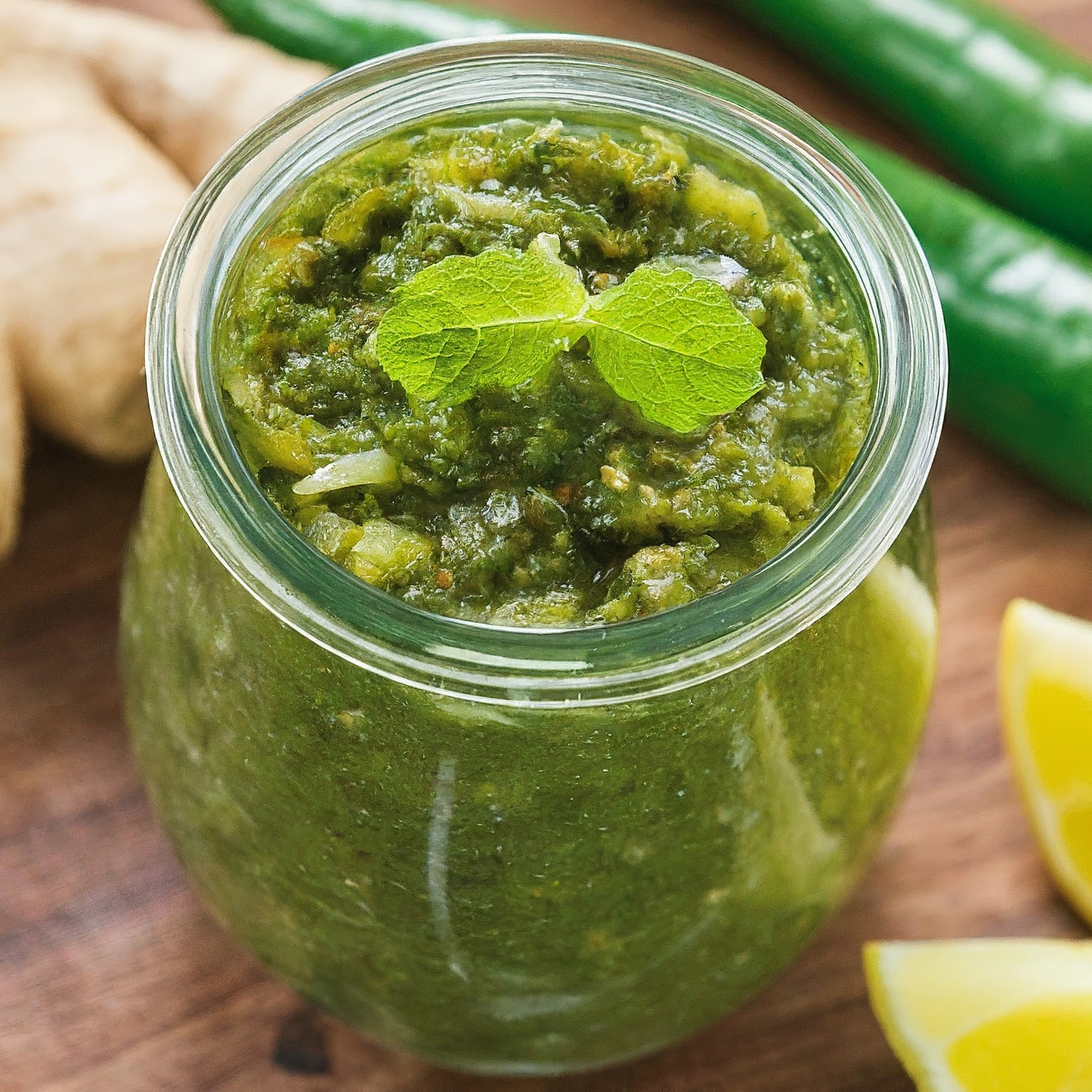 a jar of chutney with cilantro, mint, onion, ginger, green pepper, and lemon juice